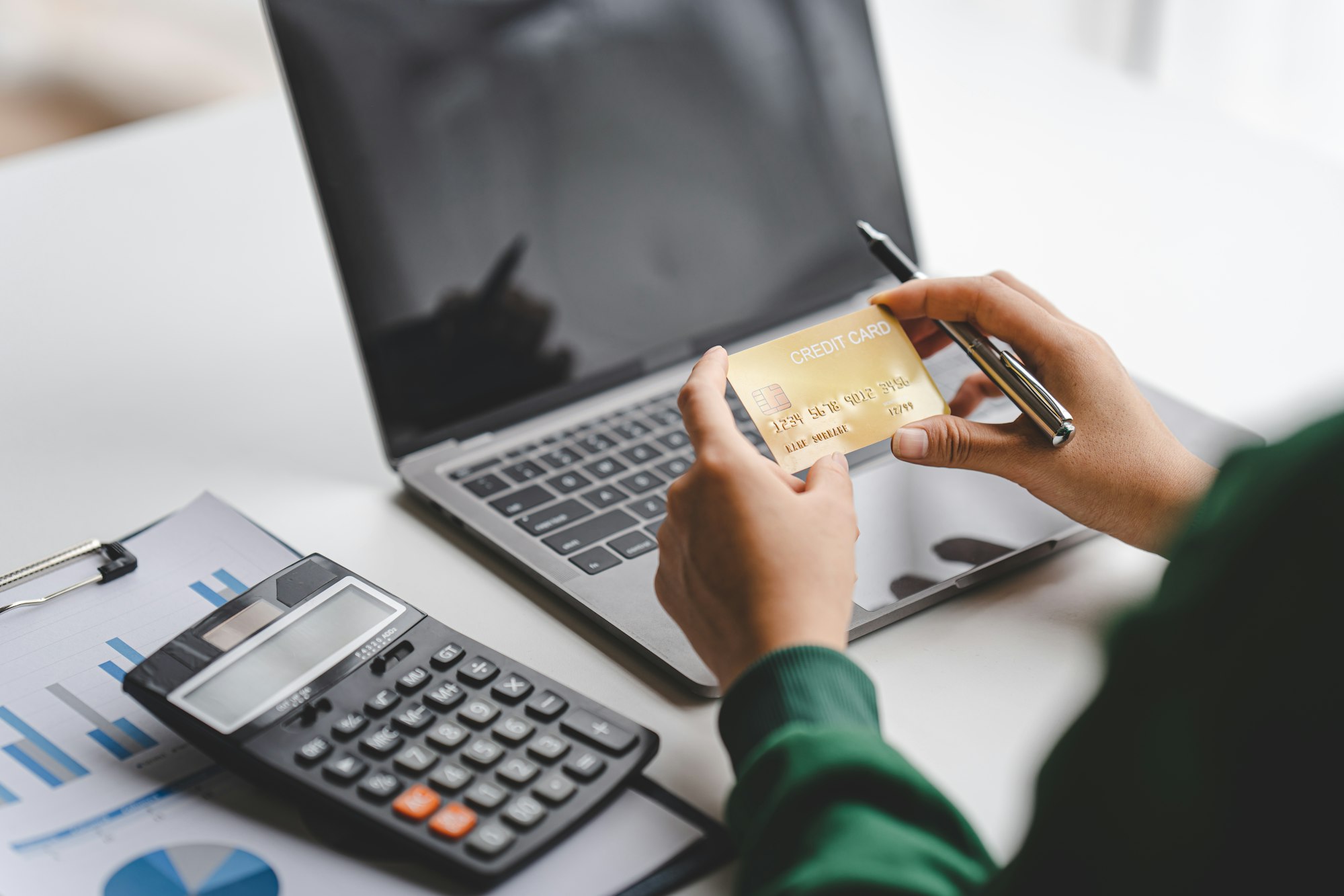 female hand holding credit card and paying online Use banking, enter information, shop, order in Int